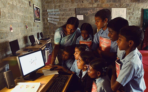 Grupp av barn runt en dator