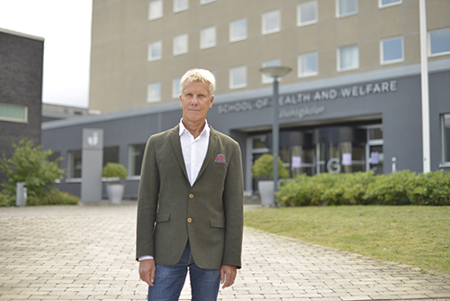 Anders Broström stands 20 metres in front of the entrance to HHJ. He is looking out towards the camera. 