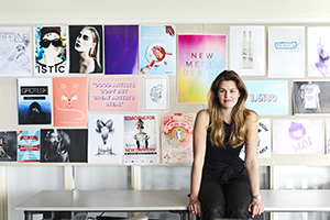 Matilda, student, stående framför en vägg med grafiska print