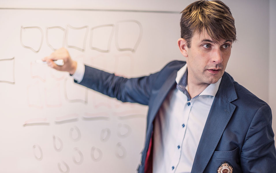 A man in front of a whiteboard